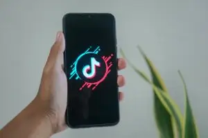 Hand holding smartphone with TikTok logo on screen, representing business growth opportunities on TikTok